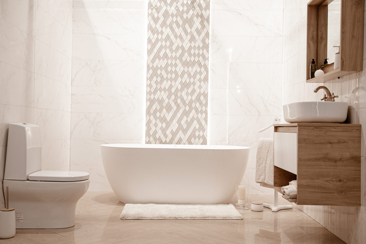 Remodeled bathroom with a freestanding tub and patterned tile feature wall