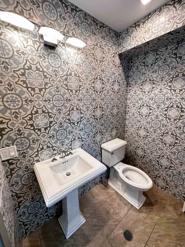 Powder Room Remodeled with patterned porcelain tiles for wall
