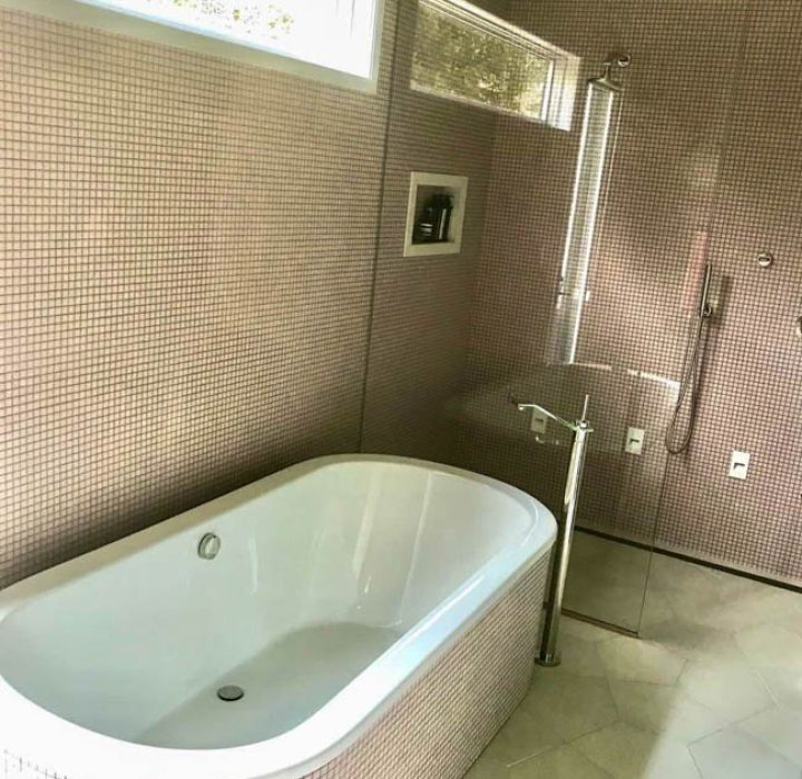 Mosaic styled bathroom wall, tub surrounds, and a marble tiled flooring