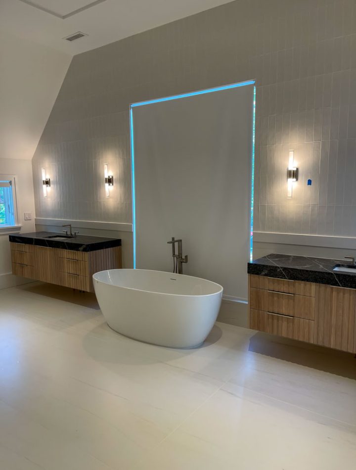 Porcelain tiled bathroom floor with freestanding bathtub in between two floating sink cabinets