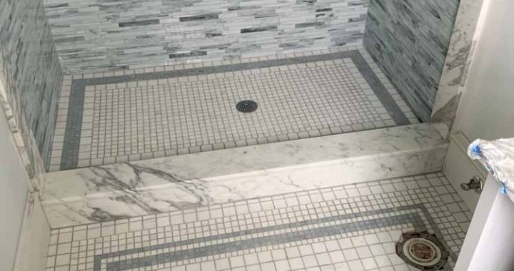 Bathroom Floor Tile uses marble mosaic design for both toilet and shower area