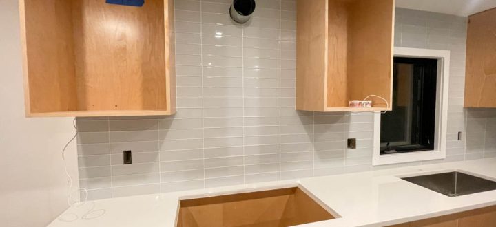 Stacked Ceramic Kitchen Backsplash with hanging cabinets and a quartz countertop