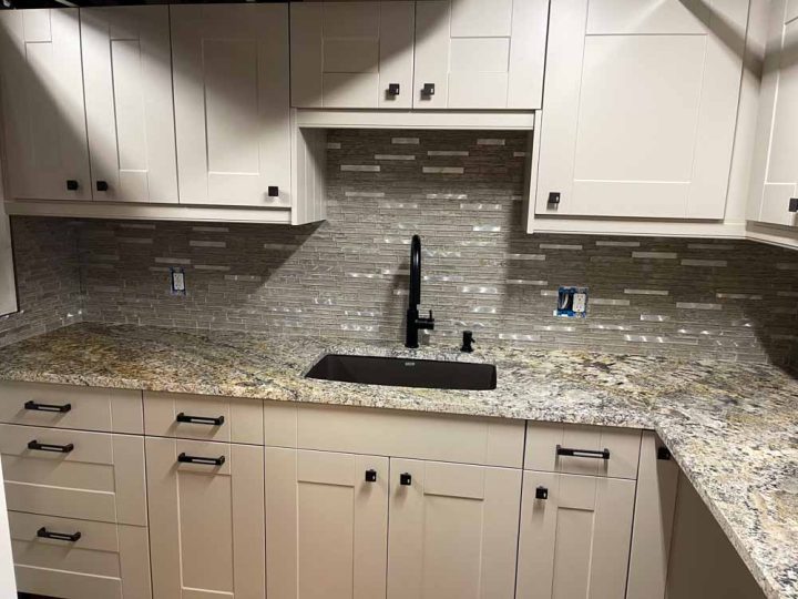 Kitchen remodeling using granite countertop and natural stone backsplash